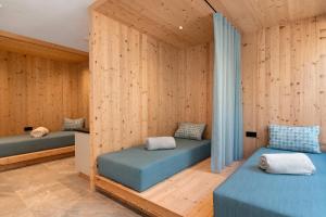two beds in a room with wooden walls at Mountain Chalet Tribulaun Pflersch in Colle Isarco +86 photos