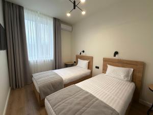 a hotel room with two beds and a window at Farmer`s Hotel in Pereyaslav