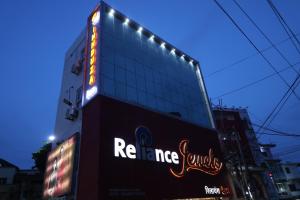 a building with a neon sign on the side of it at Innduza Inn in Begusarai