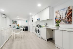 cocina blanca con lavadora y mesa en Apartment 2 New Metro 6pax, en Rivas-Vaciamadrid