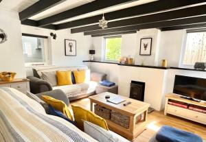 ein Wohnzimmer mit Couch und Kamin in der Unterkunft Finest Retreats - Porth Cottage in Newquay