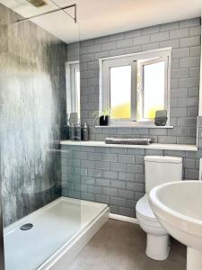 ein Badezimmer mit Badewanne, Toilette und Waschbecken in der Unterkunft Finest Retreats - Porth Cottage in Newquay