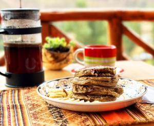 a plate with pancakes and pasta on a table at Condor's Nest in Pisac