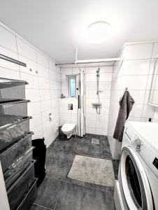a bathroom with a washer and dryer in it at Koselig og moderne 2-roms leilighet in Tromsø