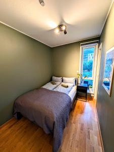 a bedroom with a bed and a window at Koselig og moderne 2-roms leilighet in Tromsø