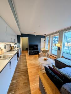 a kitchen and living room with a couch and a table at Koselig og moderne 2-roms leilighet in Tromsø