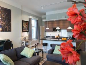 een woonkamer met een bank en een keuken bij Park Central Apartments in Den Haag
