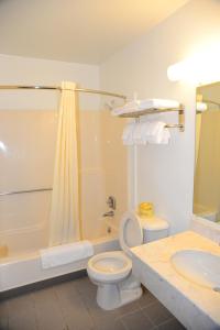 a bathroom with a toilet and a tub and a sink at Budget Inn Express in Gillette