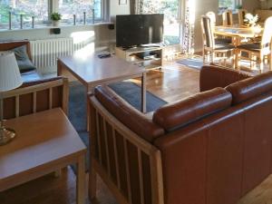 a living room with a leather couch and a table at 6 person holiday home in Hadsund-By Traum in Odde +10 photos