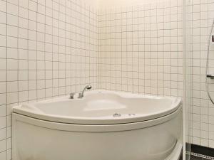 a white toilet in a bathroom with white tiles at Tranquil Retreat in Nature - By Traum Ferienwohnungen in Ålbæk