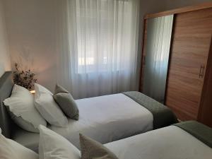 una camera d'albergo con due letti e una finestra di Apartman Romanca a Vela Luka (Vallegrande)