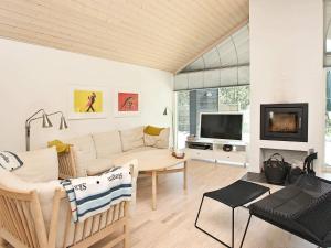 a living room with a couch and a tv at Tranquil Retreat in Nature - By Traum Ferienwohnungen in Ålbæk