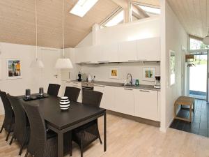 a kitchen and dining room with a black table and chairs at Tranquil Retreat in Nature - By Traum Ferienwohnungen in Ålbæk