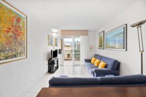 a living room with a blue couch and a tv at RIVIERA PRESTIGE - Front de Mer - Terrasse - Parking in Roquebrune-Cap-Martin