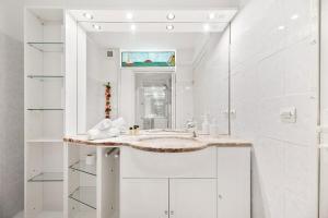 a white bathroom with a sink and a mirror at RIVIERA PRESTIGE - Front de Mer - Terrasse - Parking in Roquebrune-Cap-Martin +15 photos