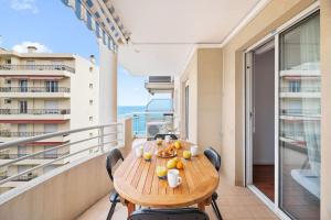a table on a balcony with a view of the ocean at RIVIERA PRESTIGE - Front de Mer - Terrasse - Parking in Roquebrune-Cap-Martin