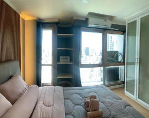 Un dormitorio con una cama con un osito de peluche encima. en Modern 59m Sukhumvit 1BR - 31st Floor Pool - Gym, en Makkasan 34 fotos más