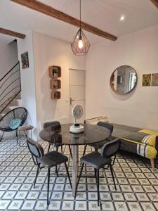 una stanza con un tavolo, sedie e un letto di Votre adresse de charme centre historique de Béziers a Béziers