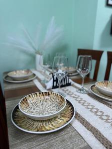a table with plates and wine glasses on it at Sweet Escape in Shkodër
