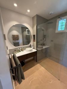 a bathroom with a sink and a shower with a mirror at Montignac Lascaux Home  +22 photos