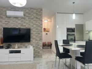 a living room with a television and a table with chairs at Wellness Way in Dunajská Streda