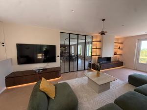 a living room with a couch and a tv at Montignac Lascaux Home 