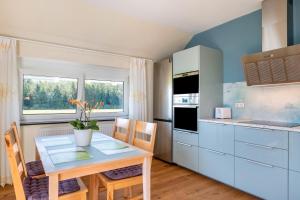 - une cuisine avec une table, une table et des chaises dans l'établissement Haus Rosengarten, à Friedenweiler