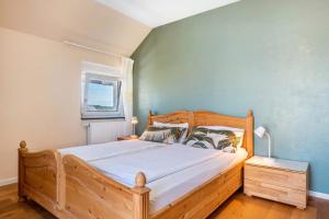 une chambre avec un lit en bois et une fenêtre dans l'établissement Haus Rosengarten, à Friedenweiler