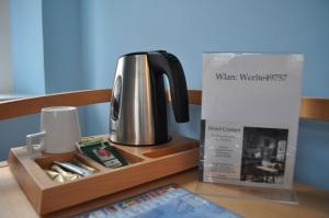 un hervidor de agua y una caja sobre una mesa en Hotel Cramer Bed & Breakfast, en Werlte
