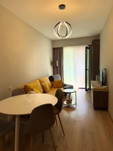 una sala de estar con un sofá y una mesa en Bakuriani Crystal Residence 625, en Bakuriani
