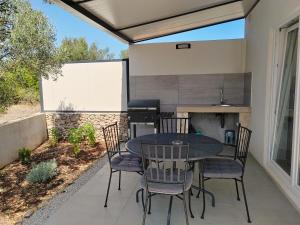 un patio con tavolo, sedie e griglia di Apartman Romanca a Vela Luka (Vallegrande)