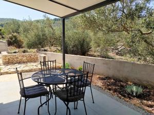 un tavolo e sedie seduti sotto un ombrellone su un patio di Apartman Romanca a Vela Luka (Vallegrande)