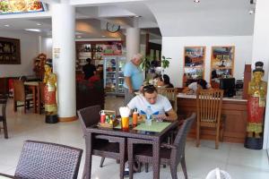 un homme assis à une table dans un restaurant dans l'établissement Sukcheewa Residence Phuket, à Patong Beach