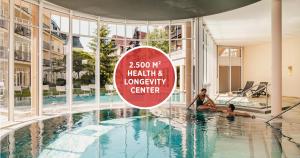 a swimming pool with a sign that reads mg health and longevity center at Falkensteiner Spa Resort Marianske Lazne in Mariánské Lázně