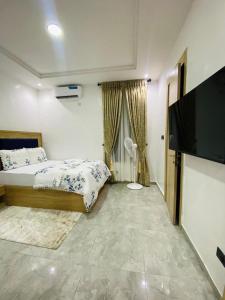 Un dormitorio con una cama y un televisor de pantalla plana. en Zizi Stay, en Ikate 6 fotos más