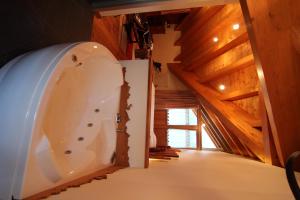 a bathroom with a tub in a room with wooden ceilings at Albergo Edelweiss - LareSpa in Crodo