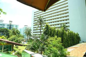un grand bâtiment avec des palmiers devant dans l'établissement Sukcheewa Residence Phuket, à Patong Beach
