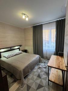 a bedroom with a bed and a table and a window at Hotels mim in Vorokhta +31 photos