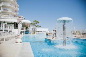 a fountain in the middle of a swimming pool at Hotel Carlton in Lido di Jesolo