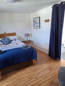 ein Schlafzimmer mit einem Bett und einem blauen Vorhang in der Unterkunft Outskirts of Coleraine in Coleraine