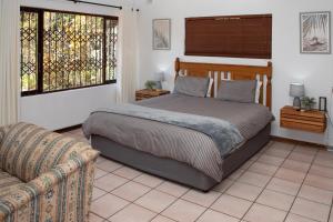 un dormitorio con una cama y un sofá en whales tail, en Port Shepstone 58 fotos más