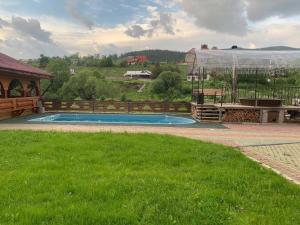 a swimming pool in the middle of a yard at Hotels mim in Vorokhta