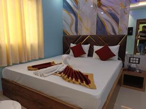 JāmbにあるVibha palaceのベッドルーム1室(白いシーツと赤い枕のベッド1台付)
