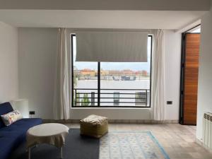 a living room with a blue bed and a large window at Villa blanche in Mirleft