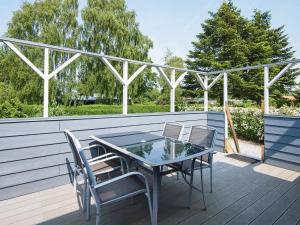a patio with a table and chairs on a deck at 4 person holiday home in Juelsminde-By Traum in Snaptun
