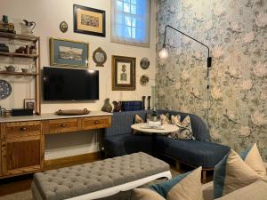 a living room with a tv and a table at Grande Roche Hotel in Paarl