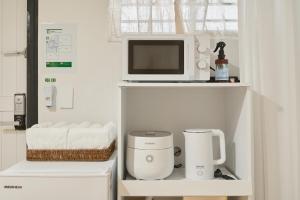 a microwave and a coffee maker on a shelf at Nonhyeon House in Seoul