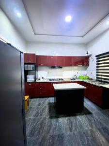 a large kitchen with red cabinets and a refrigerator at Kstephen Apartment in Lekki