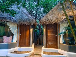a couple of huts with trees in the background at Cafe'@luv22 in Phuket Town
