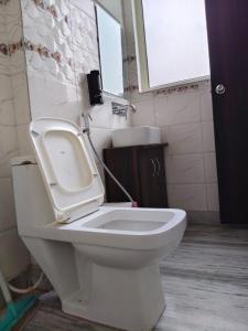 baño con aseo con lavabo y ventana en Hotel Yoga Stay Rishikesh, en Rishīkesh